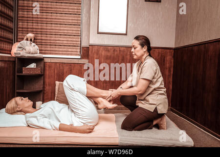 Glückliche Frau ihre Füße Massage Thai Massage Salon. Stockfoto
