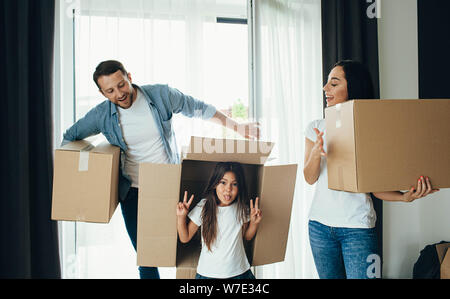 Eltern spielen mit Tochter. Familienangehörige, die neue Heimat Stockfoto