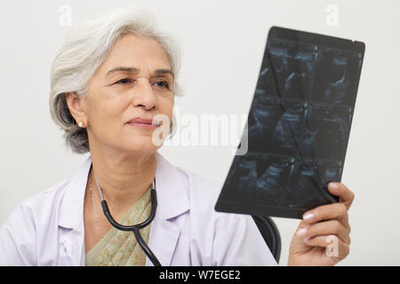 Ärztin untersucht einen Röntgen-Bericht Stockfoto
