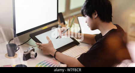 Nahaufnahme der motivierte Fotografen Zeichnung auf Tablet in seine minimalen Arbeitsplatz Stockfoto