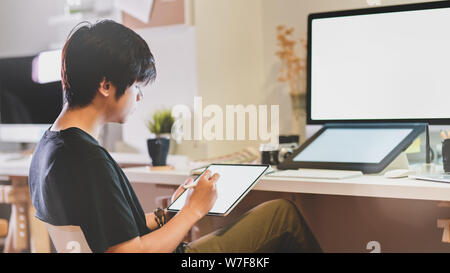 Nahaufnahme der professionelle Fotograf Retusche auf Tablet in seiner modernen Arbeitsplatz Stockfoto