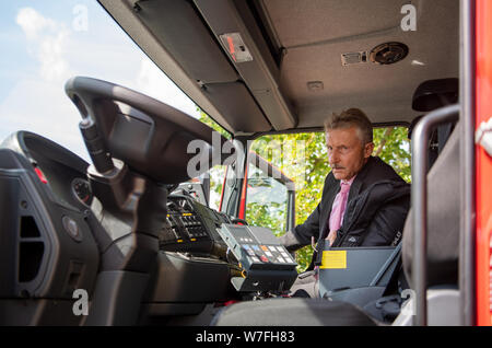 Zossen, Deutschland. 06 Aug, 2019. Karl-Heinz Schröter (SPD), Minister des Innern des Landes Brandenburg, sitzt in einem Feuerwehrauto während der feierlichen Einweihung der neuen Lage der Staatlichen Feuerwehr Schule im Ortsteil Wünsdorf Zossen. Mit dem neuen Standort der staatlichen Schule und technische Einrichtung für Brand- und Katastrophenschutz des Landes Brandenburg, die erhöhte Nachfrage nach Aus- und Weiterbildung der Feuerwehren, kurzfristig gewährleistet werden. Credit: Monika Skolimowska/dpa-Zentralbild/dpa/Alamy leben Nachrichten Stockfoto