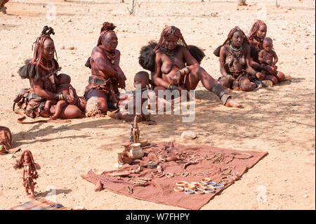 Himba Frauen verkaufen Kunsthandwerk und Schnickschnack für Touristen in ihr Dorf, Kaokoveld, Namibia, Afrika Stockfoto