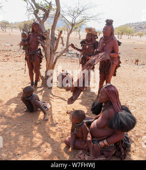 Himba Frauen verkaufen Kunsthandwerk und Schnickschnack für Touristen in ihr Dorf, Kaokoveld, Namibia, Afrika Stockfoto