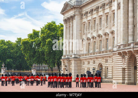 Soldaten, die im traditionellen roten Uniformen, Mitglieder der Queen's Guard, auf Parade bei der Wachablösung am Buckingham Palace, London Stockfoto
