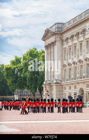 Soldaten, die im traditionellen roten Uniformen, Mitglieder der Queen's Guard, auf Parade bei der Wachablösung am Buckingham Palace, London Stockfoto
