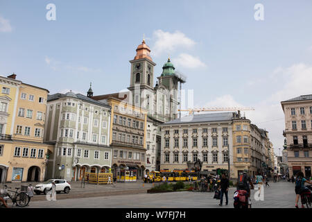 Der Hauptplatz mit seinen Geschäften und Restaurants und der alte Ignatiusdom in Linz, Österreich. Stockfoto