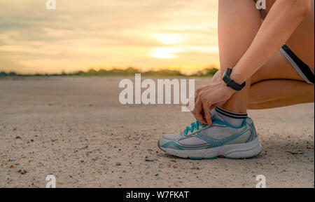 Frau runner Sport Schuhe binden und Fertig, im Park am Morgen laufen. Asiatische Frau cardio übung für gesundes Leben. Joggen im Freien. Stockfoto