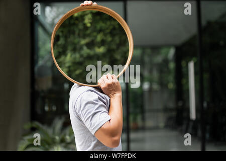 Mann, der einen Spiegel für Haus Dekoration. Stockfoto