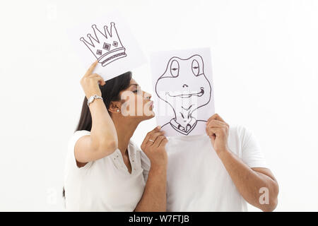 Junge Frau, die vorgibt, ein Märchen, einen Prinz Frosch küssen Stockfoto