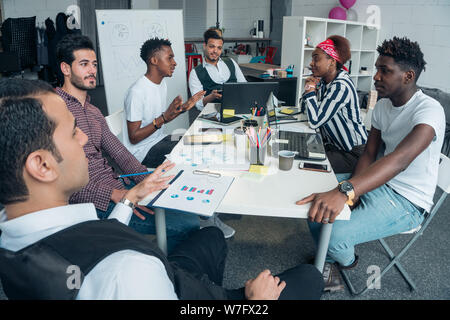 Jugendliche gemischt die Bedingungen für unternehmerische Tätigkeit zu diskutieren. Business Meeting im Büro. Stockfoto