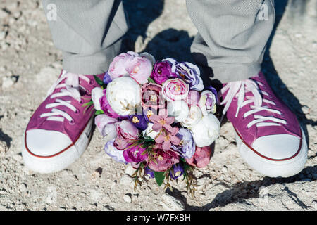 Hochzeit Details in Form von lila Turnschuhe und ein lila Wedding Bouquet. Stockfoto