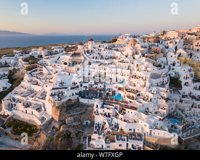 Luftaufnahme der Insel Santorini, Griechenland, das Dorf Oia mit Windmühlen und weißen Häusern. Sonnenuntergang Blick auf romantische Insel von quadcopter Stockfoto