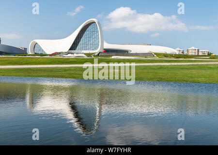 Baku, Aserbaidschan, 14. Mai 2019. Außenansicht des Heydar Aliyev Gebäudekomplex in Baku, in Wasser widerspiegelt. Durch Iraqi-British Architekt Zah konzipiert Stockfoto