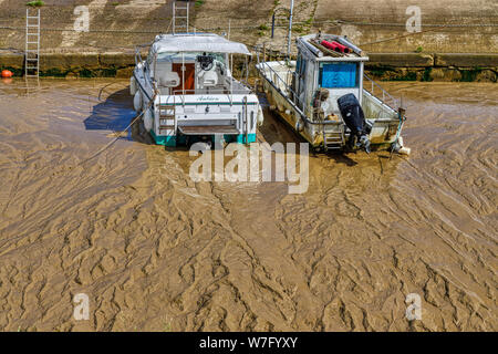 Zwei kleine Boote auf dem schlammigen Wohnungen der La Saugeron Mündung bei Ebbe in Blaye, in der Nähe von Bordeaux angesiedelt, im Département Frankreichs. Stockfoto