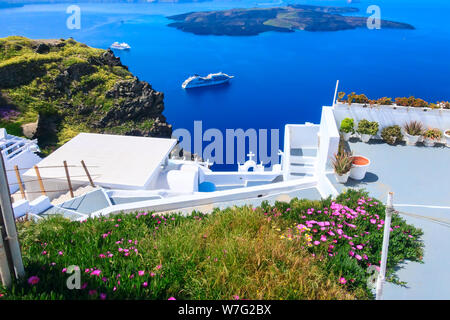 Santorini, Griechenland weisse Häuser Architektur, Hotels mit Blick auf den Einsturzkrater blaue Meer und Blumen blühen in der berühmten Insel Stockfoto