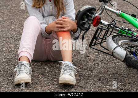 Mädchen der Schmerzen nach einem Fahrradunfall. Kinder Sicherheitskonzept Stockfoto