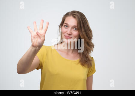 Ziemlich kaukasischen junge Frau bis vier Finger. Sie haben mehrere Möglichkeiten, Konzept Stockfoto