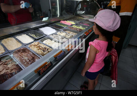 (190806) -- RAMALLAH, August 6, 2019 (Xinhua) - ein Mädchen kauft ein Eis in der Eisdiele in der West Bank Stadt Ramallah, Aug 6, 2019. Jung und Alt gleichermaßen eine Kühlung Eis an einem heißen Tag genießen. (Str/Xinhua) Stockfoto