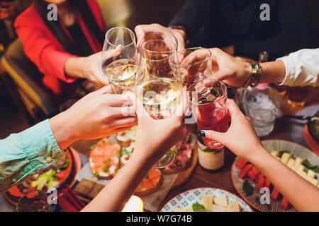 Menschliche Hände mit Gläser Rotwein zu klirren über serviert. Stockfoto