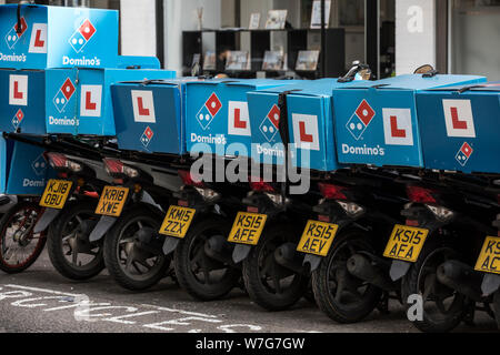 Domino's Pizza Delivery Roller untätig außerhalb einer Niederlassung auf Foley Street, London, UK Stockfoto