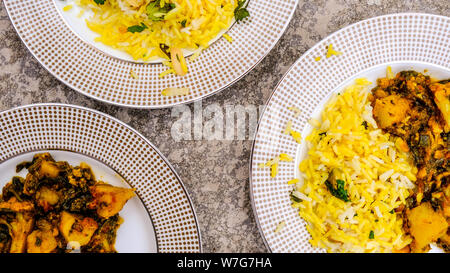 Im indischen Stil vegetarische Aloo Gobi Saag, Kartoffeln, Blumenkohl und Spinat in pikanter Soße mit Reis Stockfoto