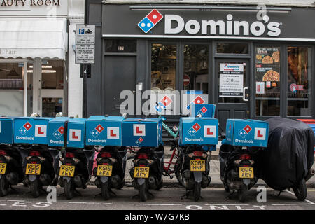 Domino's Pizza Delivery Roller untätig außerhalb einer Niederlassung auf Foley Street, London, UK Stockfoto