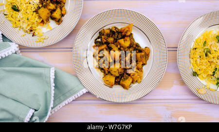 Im indischen Stil vegetarische Aloo Gobi Saag, Kartoffeln, Blumenkohl und Spinat in pikanter Soße mit Reis Stockfoto