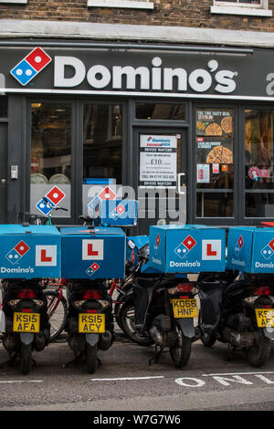 Domino's Pizza Delivery Roller untätig außerhalb einer Niederlassung auf Foley Street, London, UK Stockfoto