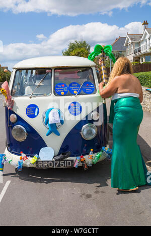 Hilf mir aus Kunststoff und Aufkleber mit Nachrichten auf eingerichteten Wohnmobil in Swanage Karnevalsumzug Prozession in Swanage, Dorset Großbritannien im Juli Stockfoto