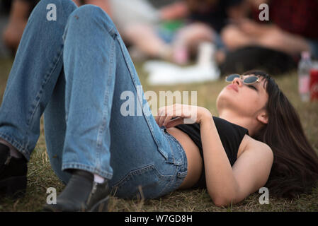 BONTIDA, Rumänien - Juli 19, 2019: Party girl entspannen und die Festlegung auf das Gras während eines Konzerts an Electric Castle Music Festival Stockfoto