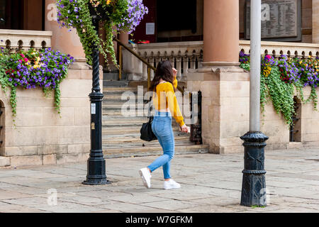 Northampton Town Center eine junge Dame, die an der Guildhall, Northamptonshire, Großbritannien, vorbeiläuft Stockfoto