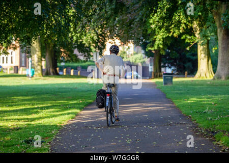 Northampton GROSSBRITANNIEN. 2. August 2019. Einen warmen, sonnigen Morgen für diese Radfahrer, reitet die Allee der Bäume in Abington Park in Richtung Park Avenue South, l Stockfoto