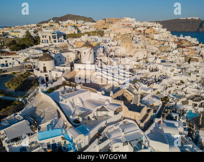 Luftaufnahme der Insel Santorini, Griechenland, das Dorf Oia mit Windmühlen und weißen Häusern. Sonnenuntergang Blick auf romantische Insel von quadcopter. Stockfoto