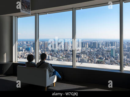 Paar sitzen und den Blick über die Stadt von der Aussichtsplattform des Roppongi Hills Mori Tower, Tokyo, Japan Stockfoto