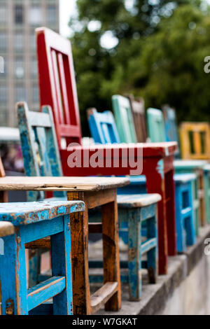 Aufstellung der bunten Stühle aus Holz in verschiedenen Größen auf einem Flohmarkt in Hannover, Deutschland Stockfoto