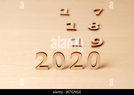 2020 Neue Jahr ändern 2019, 2018 und 2017. Holz- Nummern auf einem Leuchttisch die Änderung der Jahre symbolisieren Stockfoto