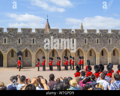 Touristen beobachten Soldaten der Haushalt Truppen während der Änderung der Palastwache Zeremonie in Windsor Castle unteren Bezirke halten, Windsor, Großbritannien Stockfoto