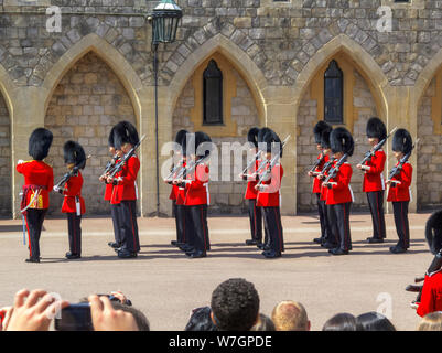 Touristen beobachten Soldaten der Haushalt Truppen während der Änderung der Palastwache Zeremonie in Windsor Castle unteren Bezirke halten, Windsor, Großbritannien Stockfoto