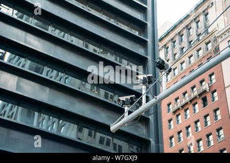 Drei Kameras auf einer Straße Pol mit großen Gebäuden im Hintergrund - Close-up Stockfoto