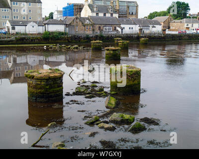 Stein Säulen im Fluss Ayr sind alle, die bleiben von der Brücke, mit der Bahn zu den Fischen Dock zu tragen. Ayr, South Ayrshire, Schottland, Großbritannien Stockfoto