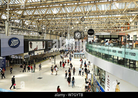 Die Menschen essen im restaurant Benugo und Käufer vorbei Geschäfte auf dem Zusammentreffen am Waterloo Station in London England UK KATHY DEWITT Stockfoto