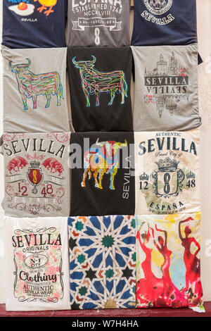 Eine Anzeige von T-Shirts mit verschiedenen Bilder von Sevilla auf ihnen für Verkauf als Souvenirs in einem Tou= rist Geschenk Shop in Sevilla, Spanien. Stockfoto