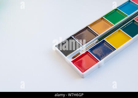 Der vollständige Satz von Wasser Color Farben auf weißem Hintergrund. Aquarellfarben in einer Kunststoffbox. Andere Aquarelle in der Palette. Platz kopieren Stockfoto