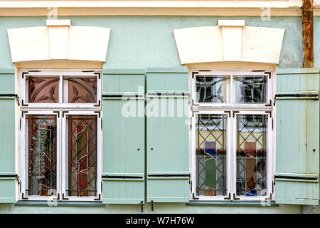 Zwei rechteckigen Fenstern mit weißem Rahmen und grüne Fensterläden aus Holz. Aus einer Reihe von Windows der Welt. Stockfoto