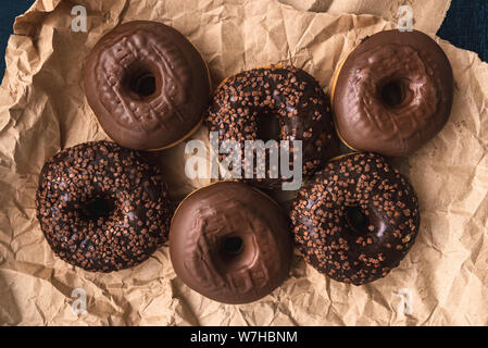 Blick von oben auf die leckere hausgemachte Schokolade Donuts auf der Verpackung Handwerk Papier Stockfoto