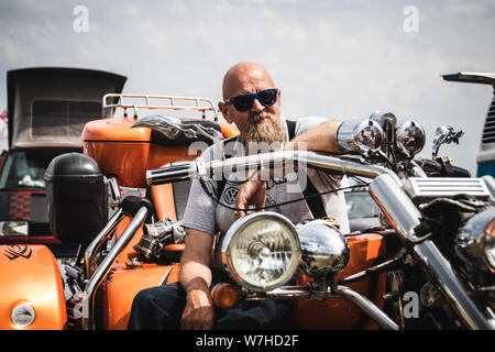 Das Porträt einer mittleren Alters Biker auf seinem Motorrad Stockfoto