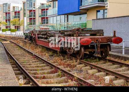 Ein stillgelegtes Fahrzeug auf der Erbe Hafenbahn auf Bristol quayside vor der modernen Wohnungen auf Museum Straße. Bristol, UK. Juli 2019. Stockfoto