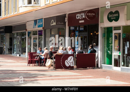 Die Menschen saßen draußen ein Costa Coffee Shop genießen eine Tasse Kaffee in der Sonne Stockfoto