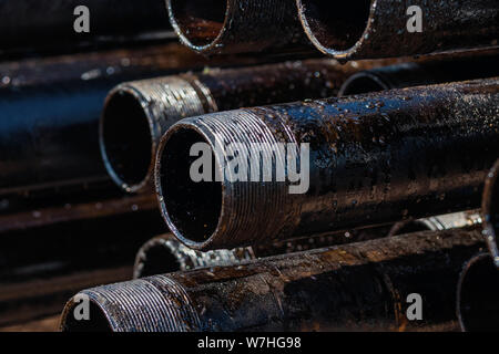 Ansicht Bohrung Leitungen Gehäuse und Schläuche am Hof von Öl und Gas Lager gestapelt. Stockfoto